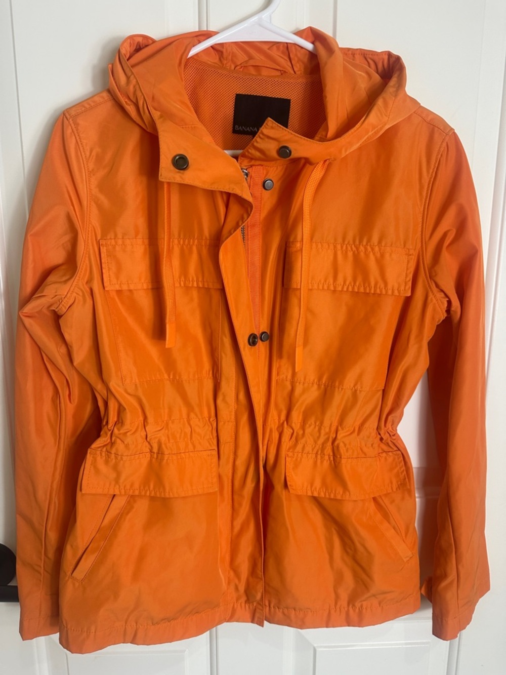 Like new. Banana Republic XS orange raincoat. Hood. Drawstring waist.